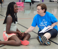 Two Girls on the Run coaches smiling as they read lesson